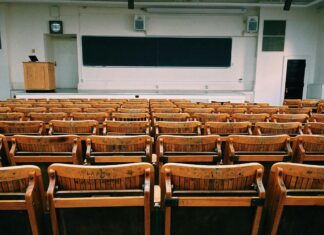 IAALS, LSAC Launch Foundations 2.0, Addressing a Post-COVID Legal Profession Undergoing Fundamental Shifts rows of empty seats in front of a lectern.