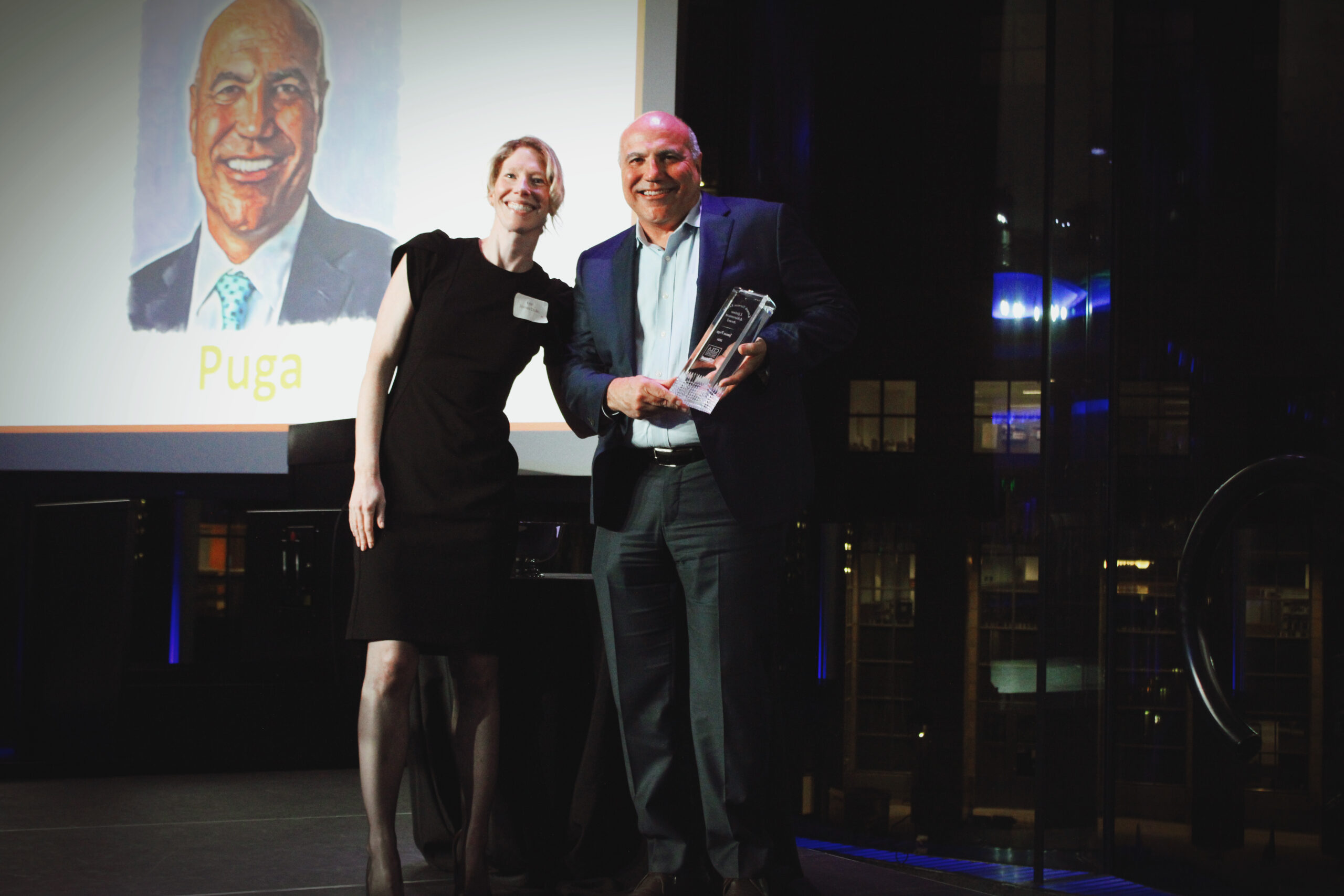 Jim Puga holds his Kenneth Norman Kripke Lifetime Achievement Award and poses with CTLA President Kari Jones Dunlin