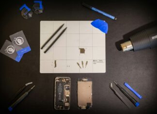 Colorado Becomes State with Broadest Repair Rights in the Country A phone, taken apart, lies on a black table with repair tools around it.