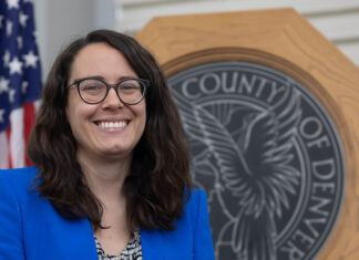 Denver City Council Passes Ballot Question on City Workers’ Rights to Collectively Bargain, Strike At-Large Denver City Council Member Sarah Parady stands in front of the seal of the City and Council of Denver.