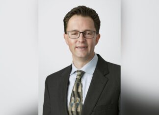 Holland & Knight Partner Stephen Dietrich Details his Mental Health Journey as an Attorney Stephen Dietrich smiles in a headshot photo, wearing a black suit with a black and brown patterned tie.