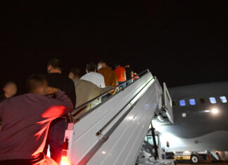 After a Series of Executive Orders Changing Immigration Policy, Nonprofits Work to Respond A group of men stand on a staircase waiting to board a plane that will remove them from the United States and return them to Colombia.