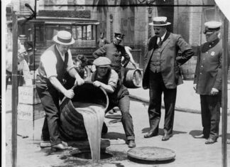 Denver’s Failed Attempt to Resist Alcohol Prohibition A group of police officers supervise as two men pour a barrel of liquor into the sewers.