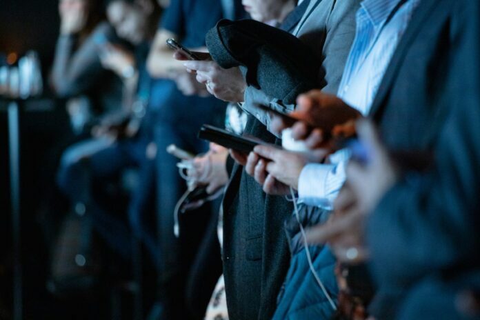 camilo-jimenez-qZenO_gQ7QA-unsplash A group of people stare at their phones.
