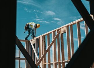 Bill Expanding Doctor Choice in Workers’ Compensation Cases Clears Committee A construction worker standing on top of house scaffolding.